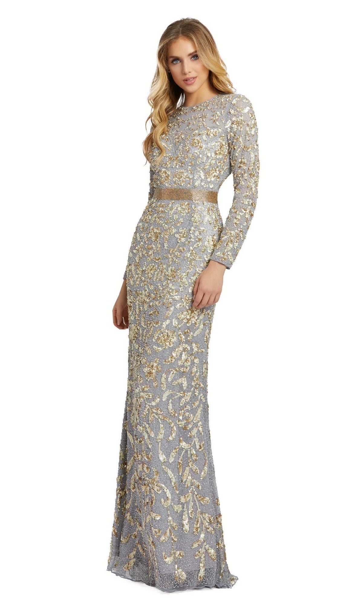 A woman wearing the Long Formal Dress 4316 by Mac Duggal, a platinum floor-length gown with long sleeves, gold embroidery, and sequin embellishments, stands against a plain white background.